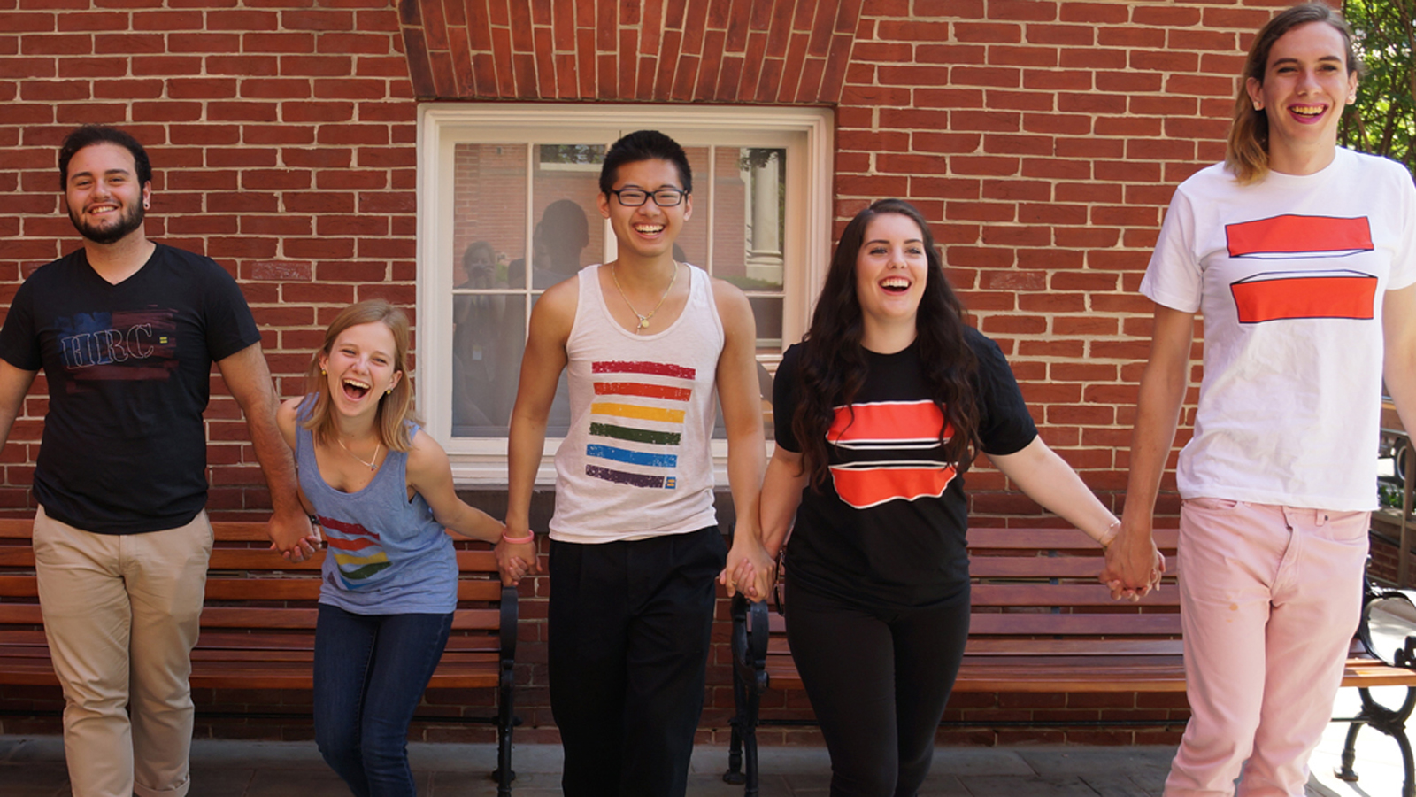 Teenagers holding hands wearing equal sign shirts