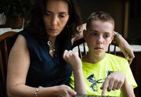 Mother and son at table with tablet