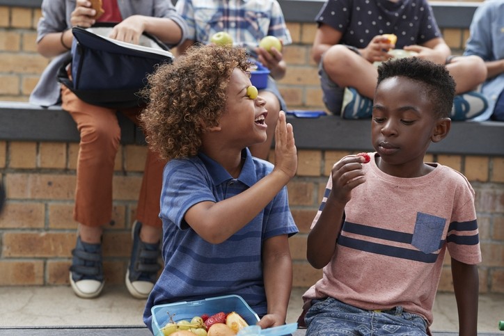 School children having lunch together outside the building